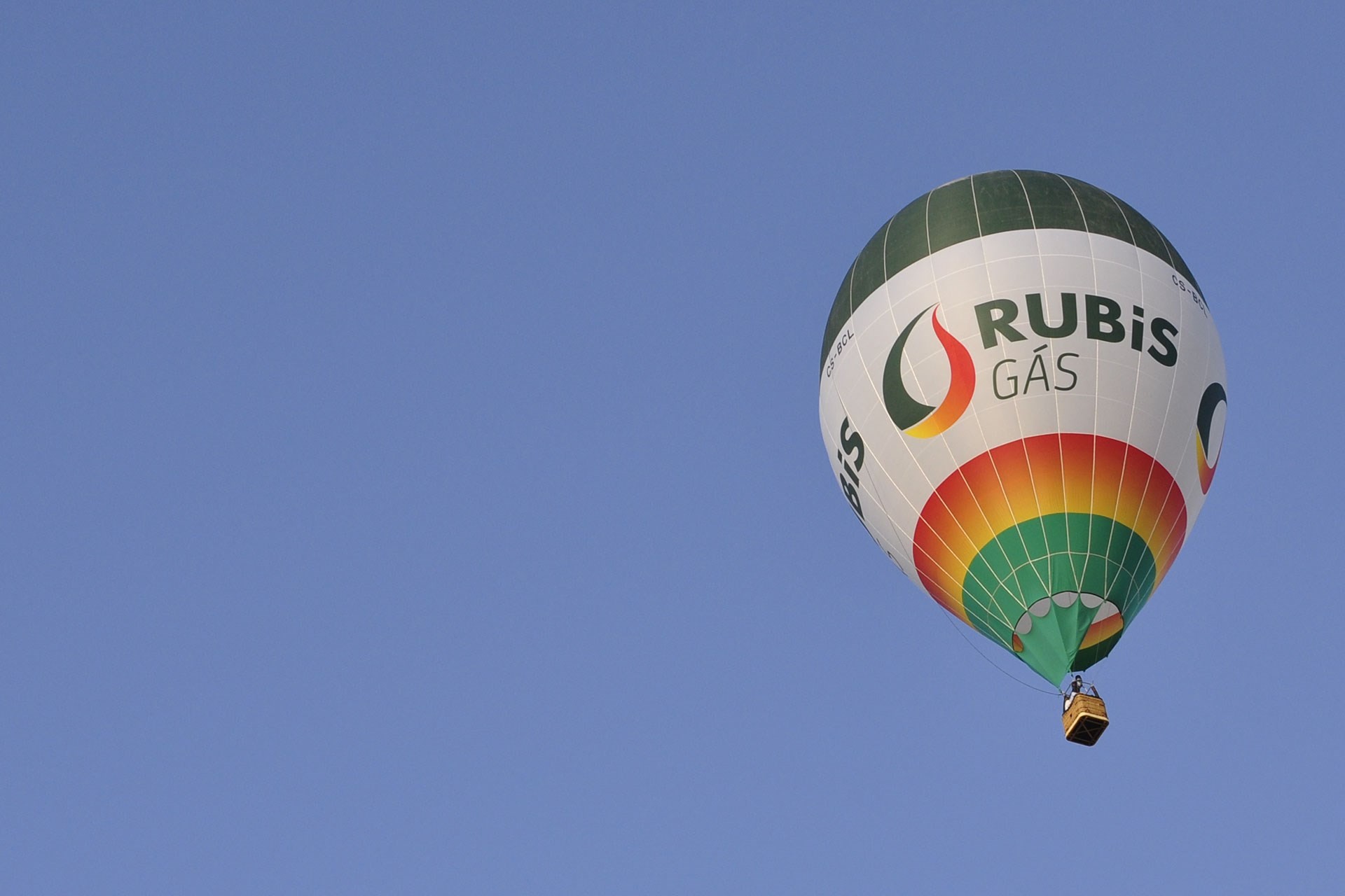 Balão de ar quente personalizado com o logótipo e cores da Rubis Gás a voar num céu azul.