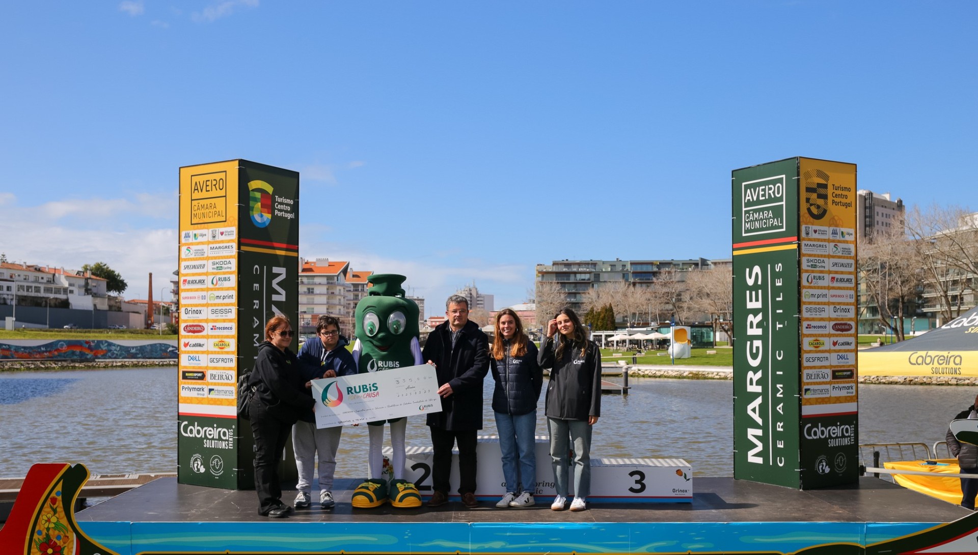 Entrega do cheque simbólico da iniciativa Rubis por uma Causa a representantes da CERCIESTA no pódio do Aveiro Spring Classic, junto ao canal.