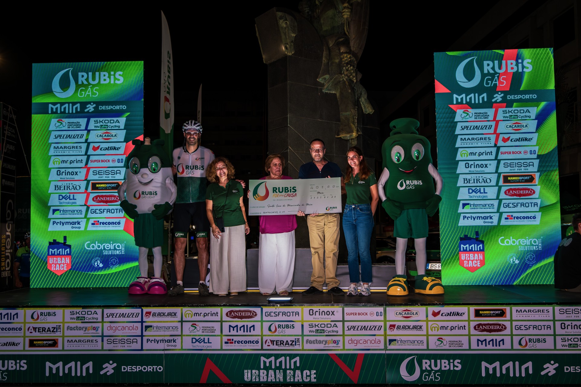 Entrega do cheque simbólico da iniciativa Rubis por uma Causa no palco do Maia Urban Race, acompanhada pelas mascotes da Rubis Gás.