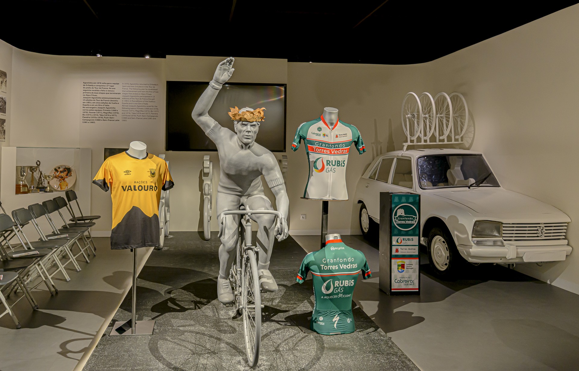 Estátua do ciclista Joaquim Agostinho rodeada pelas camisolas oficiais do Granfondo Torres Vedras com o patrocínio da Rubis Gás.